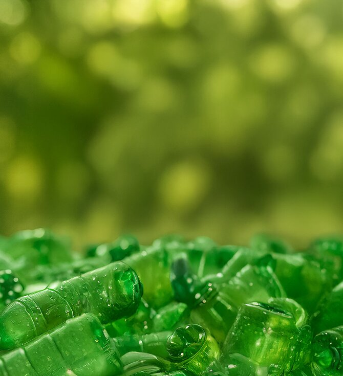 Gjenvunne grønne plastflasker – symbol på bærekraftig produksjon av resirkulerte tekstilprodukter.