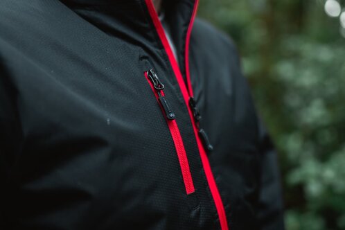Nærbilde av Stormtech jakke med vanntette glidelåser og røde detaljer