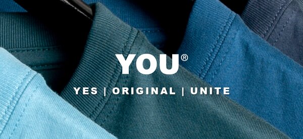 YOU® - YES | ORIGINAL | UNITE. Nærbilde av fargerike tekstiler med YOU-logoen i hvitt.