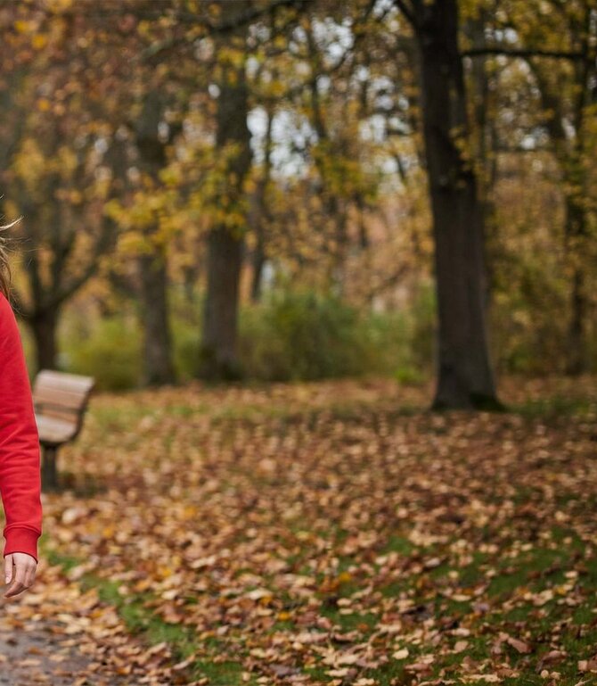 Høstlig parklandskap med nedfalne blader – bakgrunn brukt for å fremheve Clique Classic Hettegenser. 
