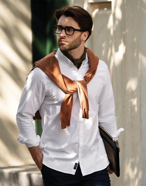 Nærbilde av en person i Cemo Care-T-skjorte som holder en håndfull nybrente kaffebønner.