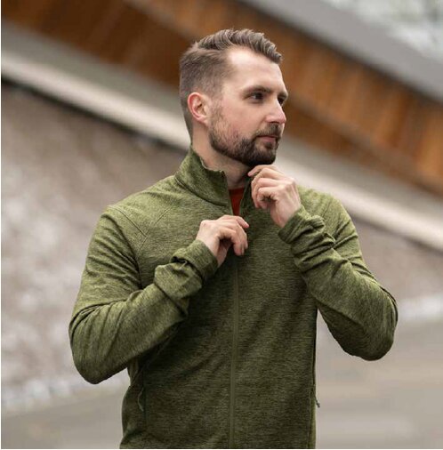 Mann iført grønn Stormtech fleecejakke med glidelås