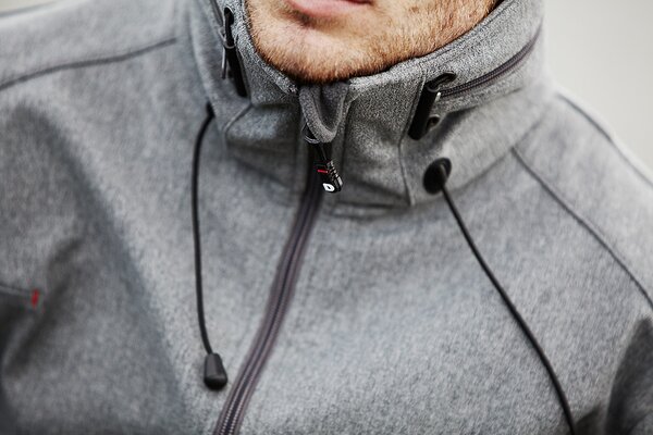 Nærbilde av grå hettejakke fra D.A.D Sportswear, med funksjonelle detaljer og sporty design.