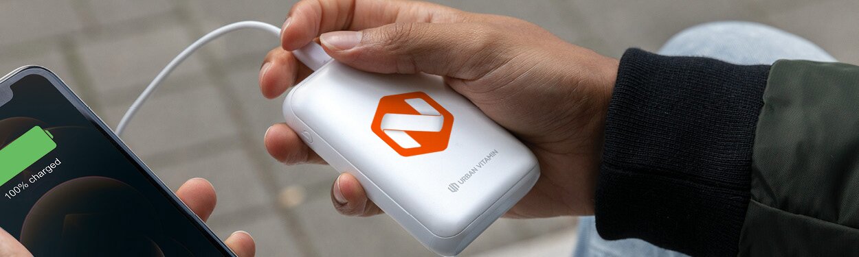 Moderne hvit powerbank med trykket firmalogo, koblet til en mobiltelefon for lading. Perfekt profileringsprodukt for teknologibevisste kunder. 