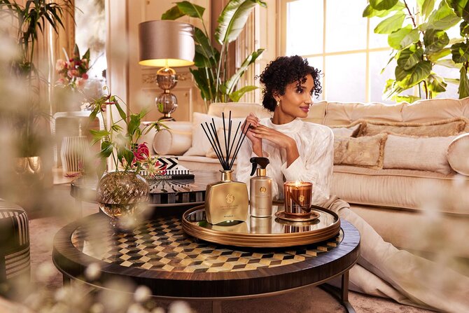 Kvinne nyter en avslappende stund i en stilfull stue med duftpinner, lys – en perfekt påskegave for velvære og hjemmekos.