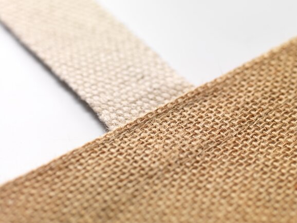 Nærbilde av slitesterkt og miljøvennlig jutestoff på et handlenett – bærekraftig profilprodukt for bedrifter.