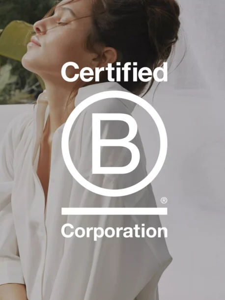 Kvinne i hvit bluse med teksten ‘Certified B Corporation’ i front, som viser Rituals’ sertifisering.