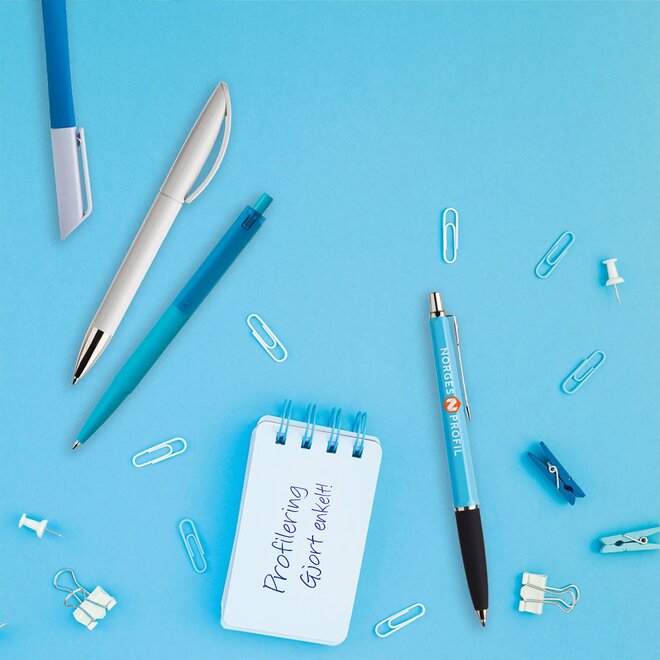 Flotte reklamepenner med firmalogo, omgitt av kontorrekvisita – et praktisk profilprodukt med lang levetid.