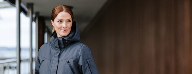 Kvinne i Stormtech skalljakke med hette i urban miljø