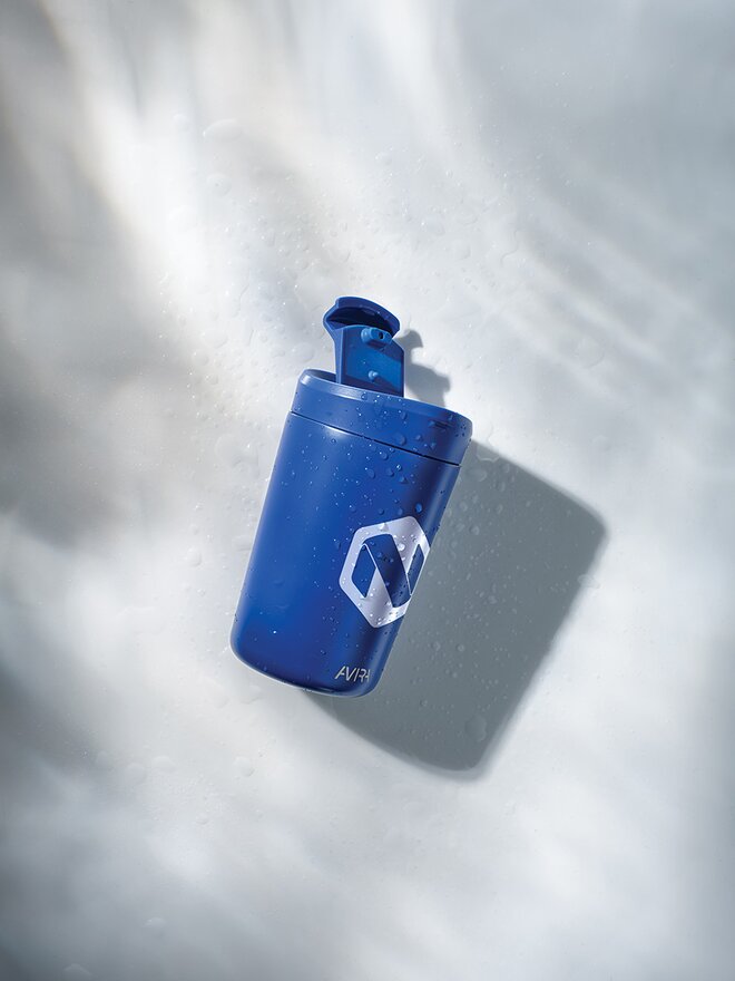 Blå termokopp med firmalogo, plassert på en lys bakgrunn med skyggeeffekt. Ideell som profileringsartikkel og giveaway.