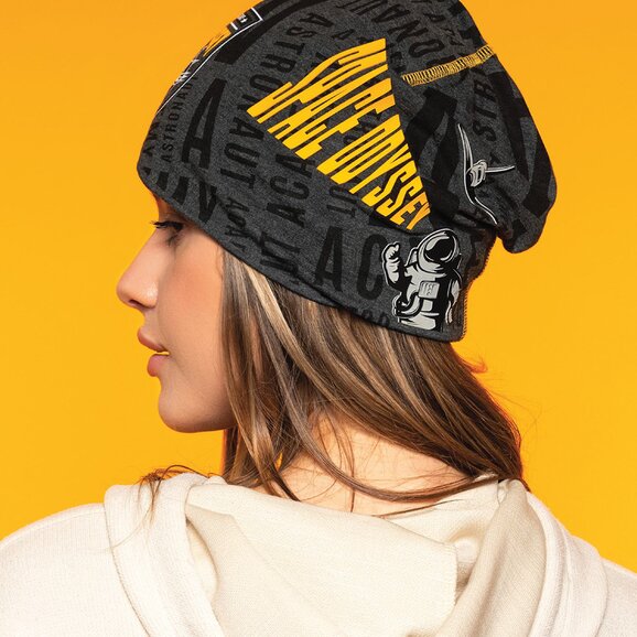 Kvinne med trendy, mønstret lue i svart og gult med trykk. Perfekt profileringslue for bedrifter, events og giveaways. 