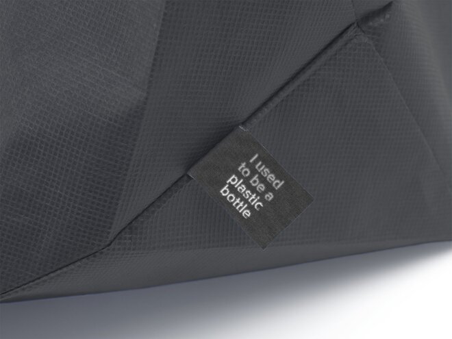 ærbilde av et svart handlenett med label som sier 'I used to be a plastic bottle', som viser produktets bærekraftige opprinnelse.