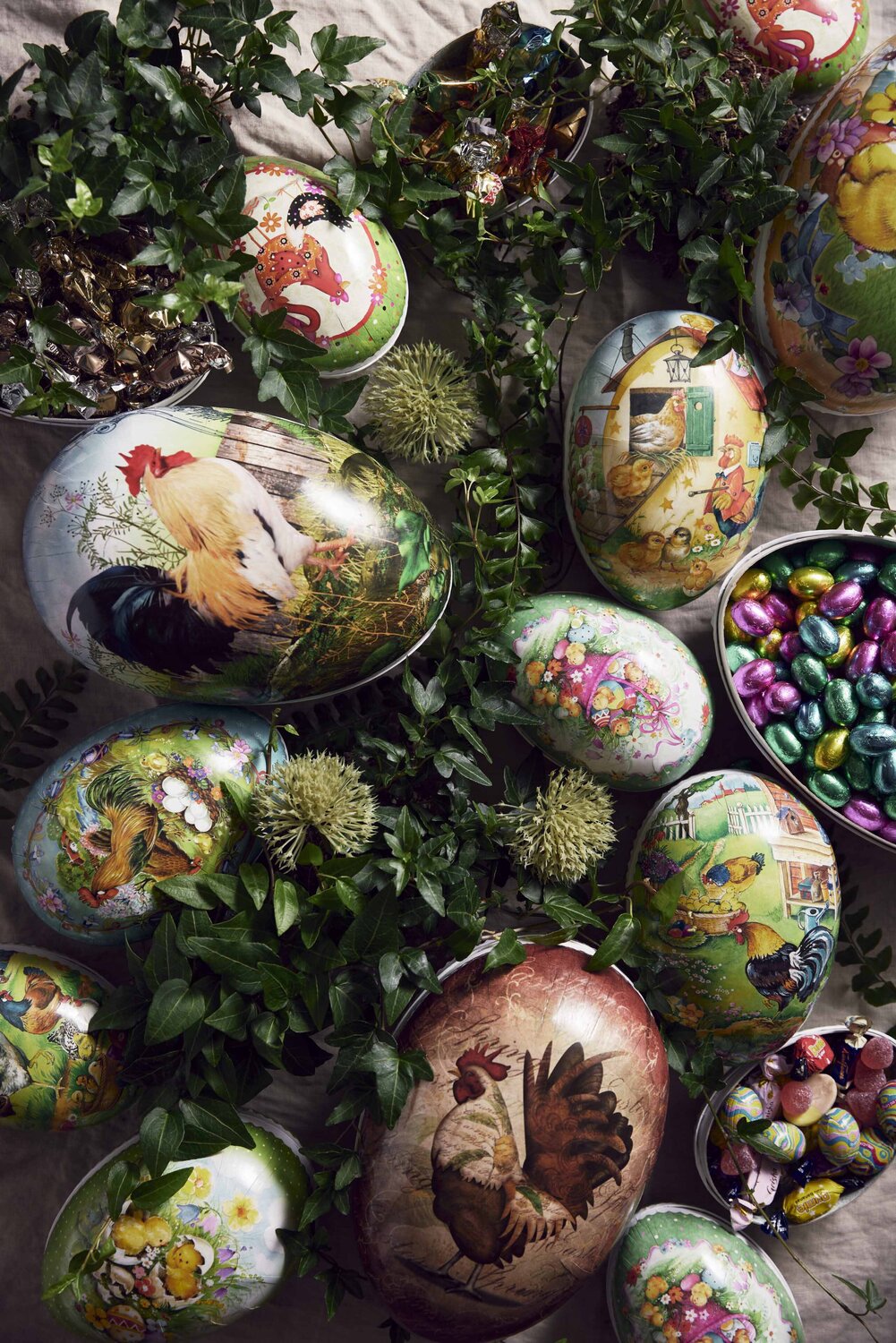 Dekorative vintage påskeegg fylt med sjokolade og godteri, omgitt av grønn påskepynt – en klassisk og sjarmerende påskegave.