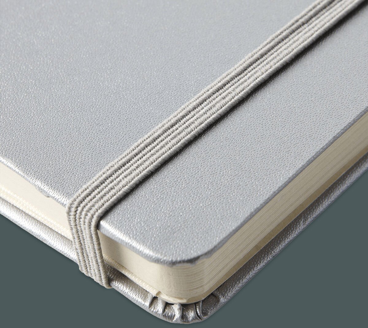 Detaljert visning av en JournalBooks-notatbok i sølvgrå farge, med elastisk bånd som holder sidene samlet. Notatboken har avrundede hjørner og en luksuriøs tekstur.