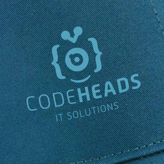 Nærbilde av trykk på caps – Blå caps med trykket logo i kontrastfarge. Trykket gir en presis og stilren profilering, ideell for capser med fem paneler og glatte overflater.