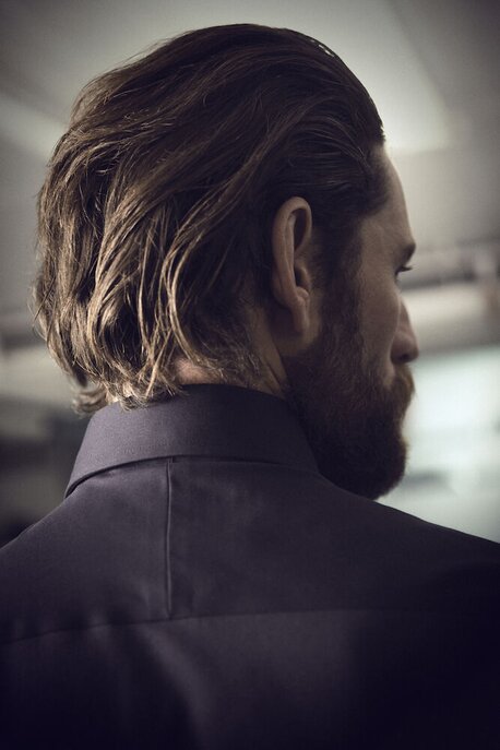 Bakhodet og nakken til en mann iført en mørk J. Harvest & Frost-skjorte, med fokus på kragen.