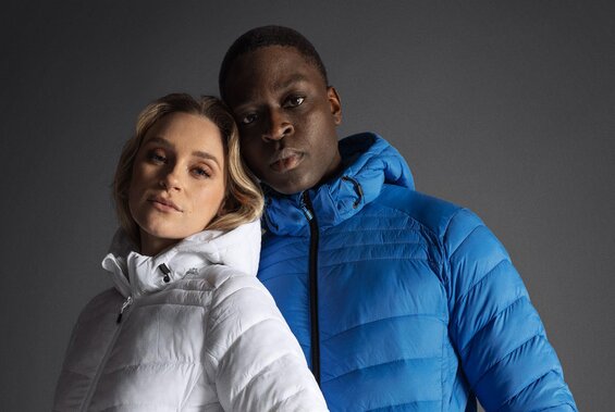 Mann og kvinne i hvit og blå boblejakke fra Printer, mot mørk bakgrunn.