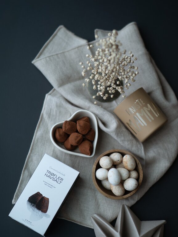 Luksuriøs påskegave med sjokoladetrøfler og sjokoladeegg, vakkert dandert på stoffduk – perfekt gave til påskehøytiden.