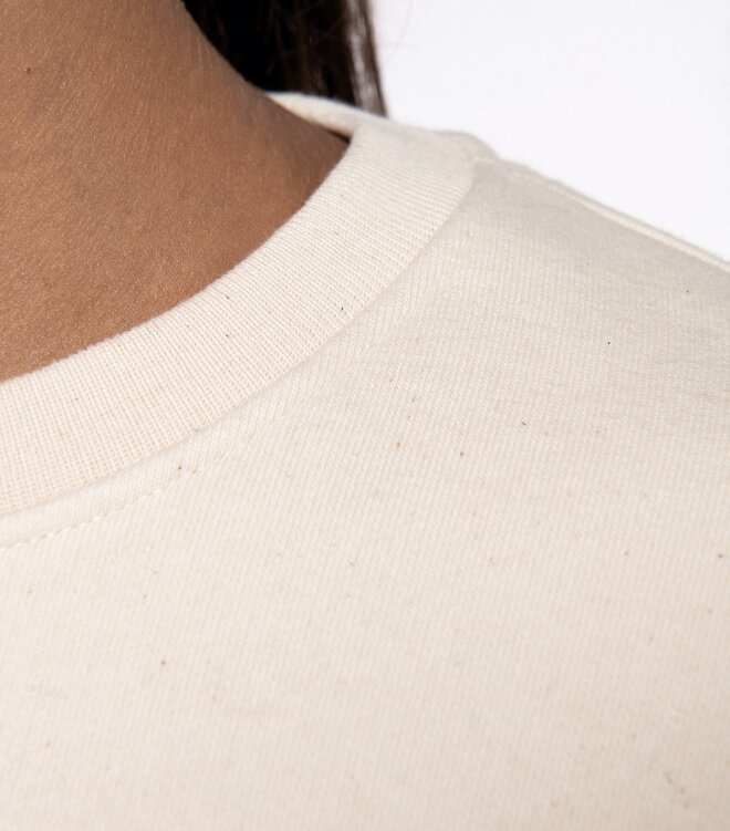 Nærbilde av teksturert stoff og ribbestrikket halskant på en bærekraftig collegegenser – profilklær av høy kvalitet.