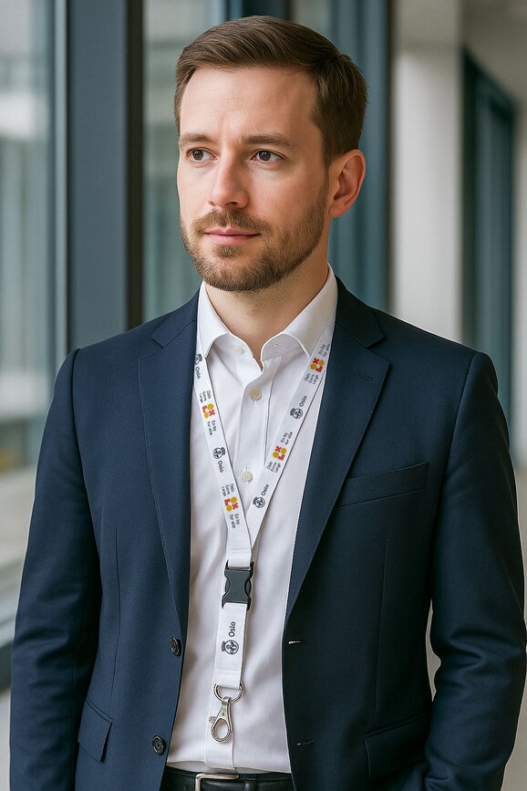 Mann i dress med hvitt logobånd med trykk – profesjonell profilering med nøkkelbånd til kontor og konferanser.