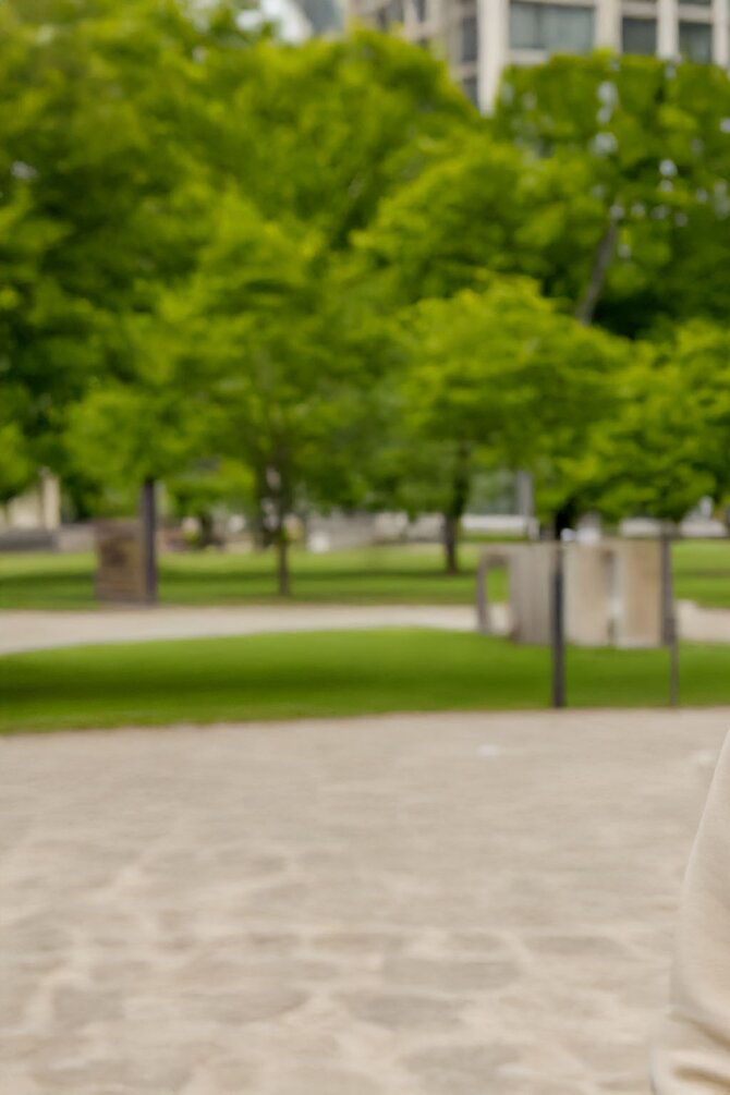 Uskarp park med trær – naturlig bakgrunn brukt i produktpresentasjon av miljøvennlig caps.