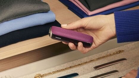 Small group of people is sitting in a café, drinking coffee with the Ploom logo.