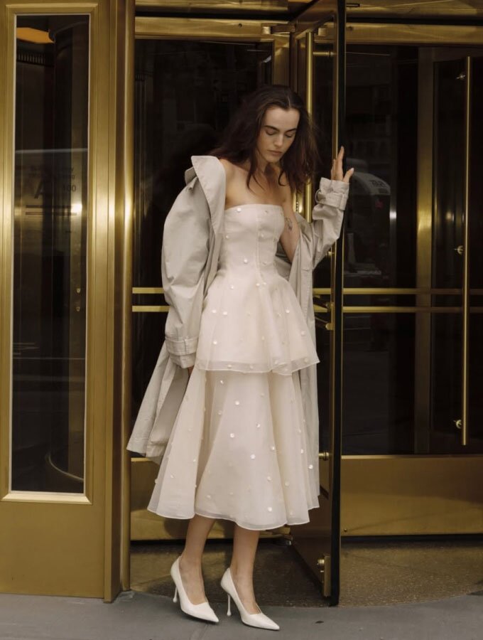 A woman wearing a matching cream-colored embellished strapless bustier top and A-line skirt