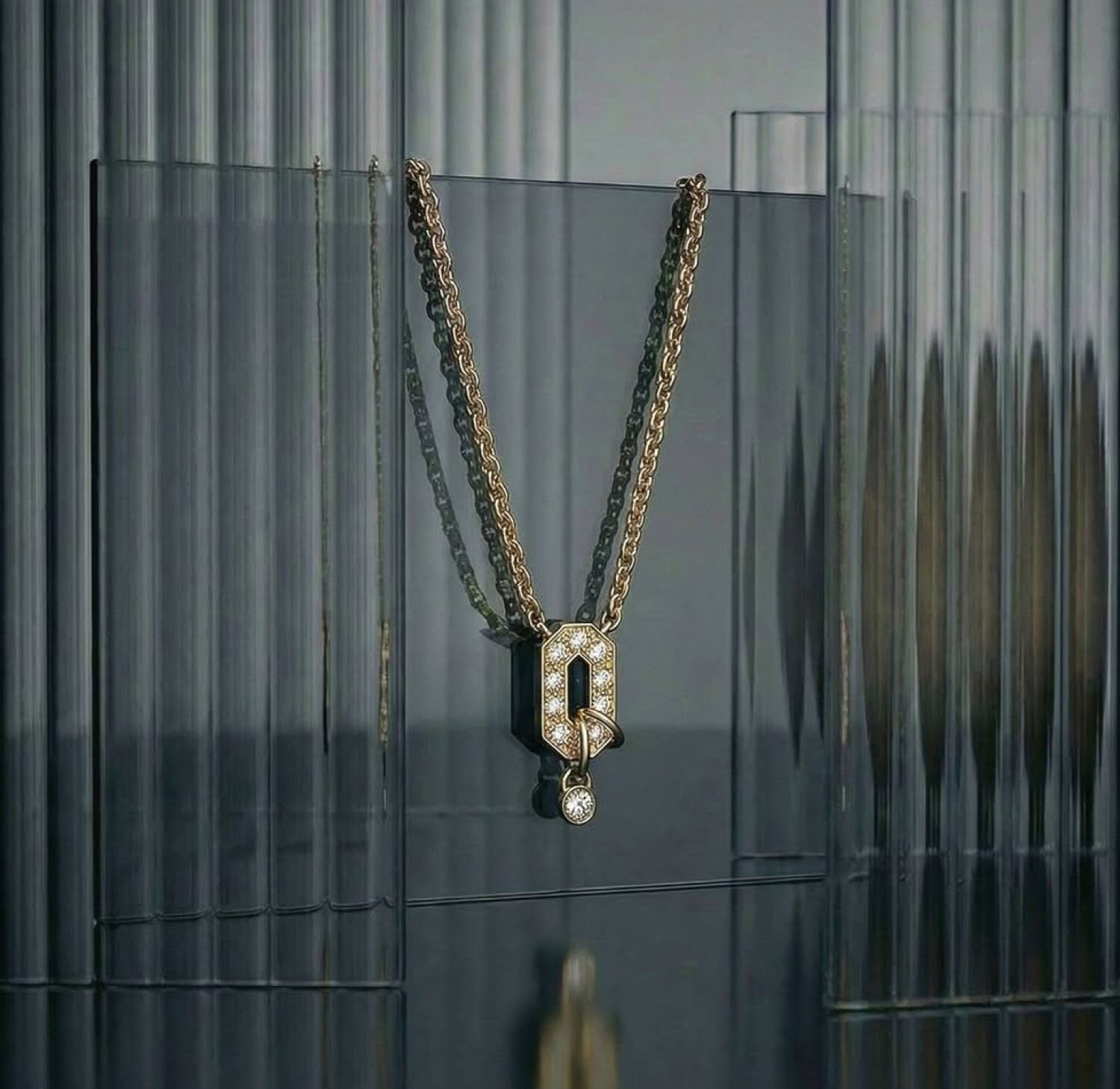 A yellow gold art deco-inspired pendant necklace featuring diamond embellishments