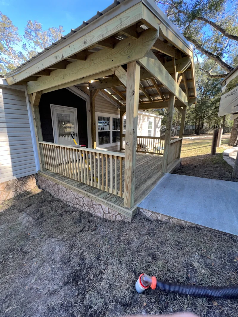Covered side porch with a wood railing and metal roof