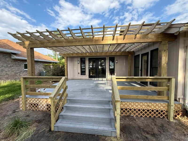 Raised deck with a timber pergola and stairs