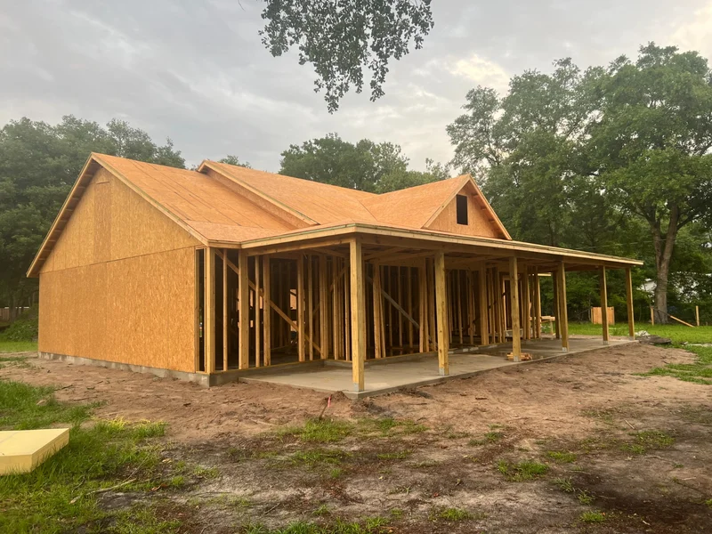 New home under construction with framing and roof sheathing