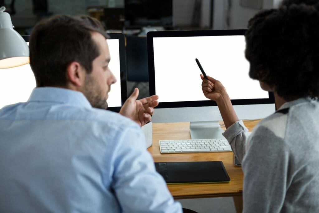 man and woman talking in front of a computer shutterstock