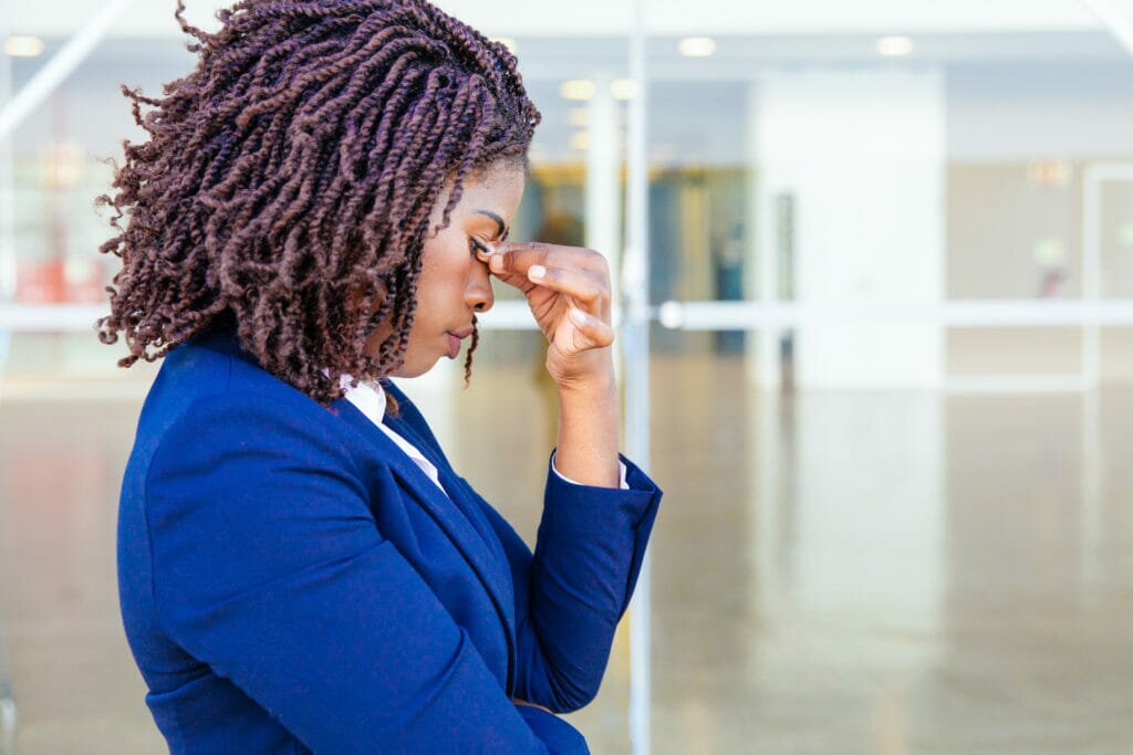 A businesswoman looking worried outside her work building