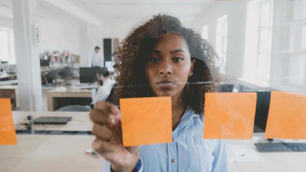 A product managers working with post its on a wall