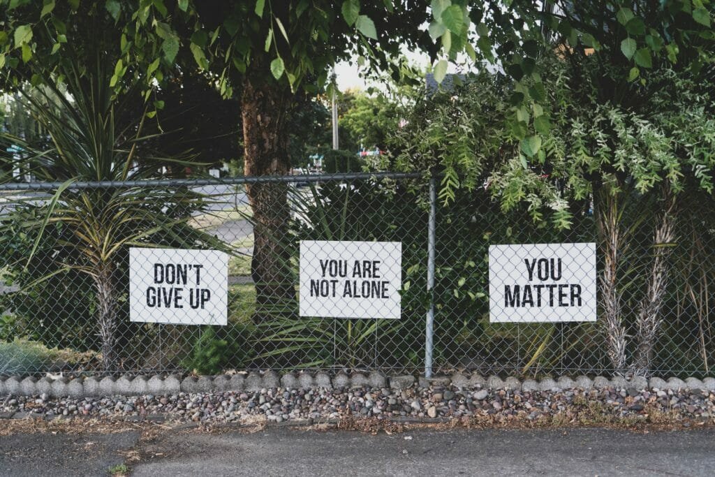 Signs saying don't give up, you are not alone and you matter