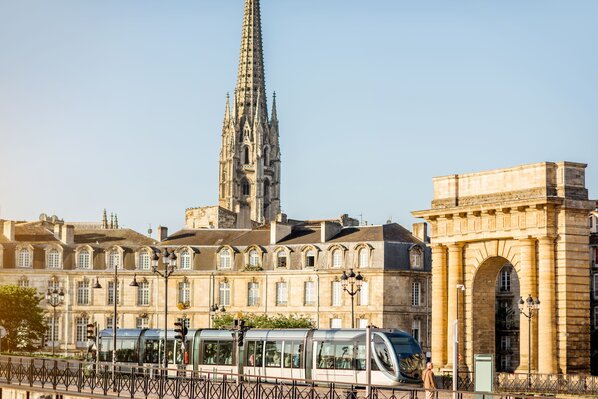 Seaside view on the famous Bourgogne gates and tower of saint Michel cathedral during the morning light in Bordeaux city, France