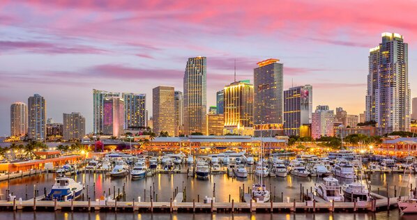 Miami city skyline panorama at twilight with urban skyscrapers, marina and bridge
