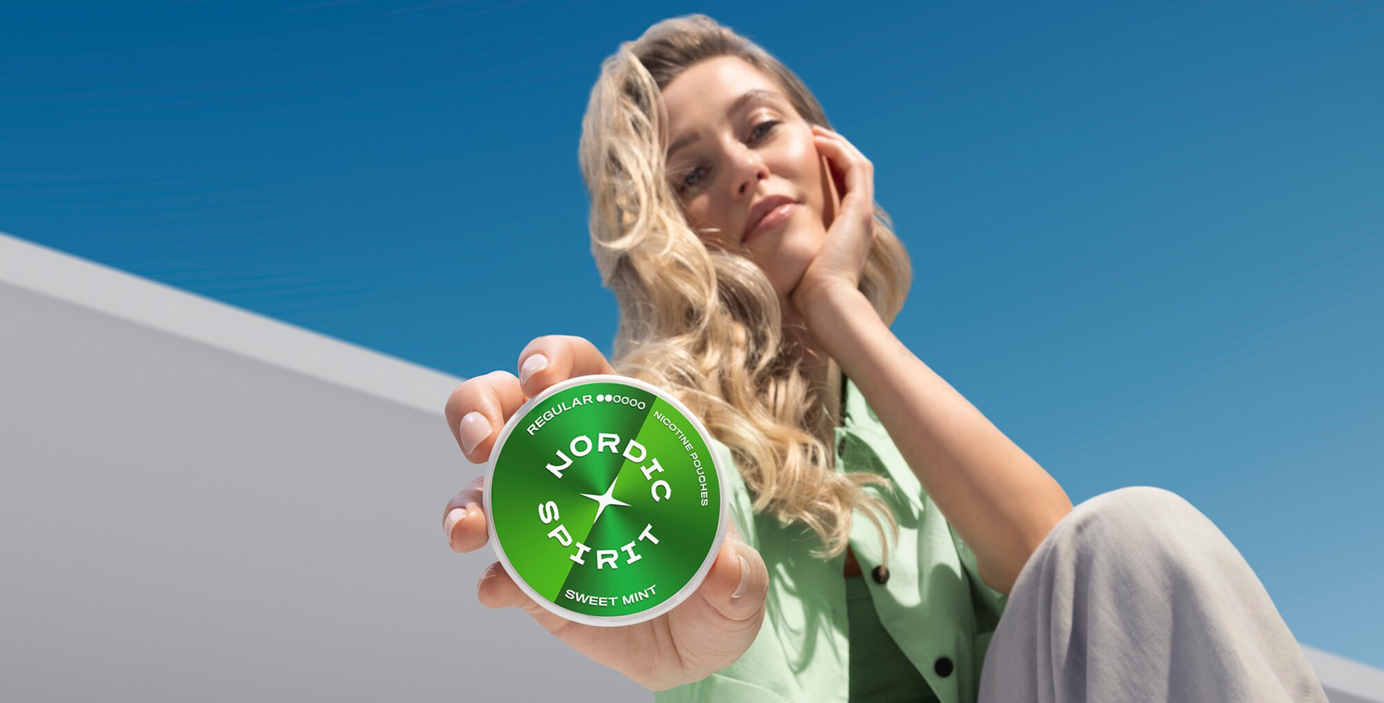 Femme avec une boîte de sachets de nicotine Sweet Mint