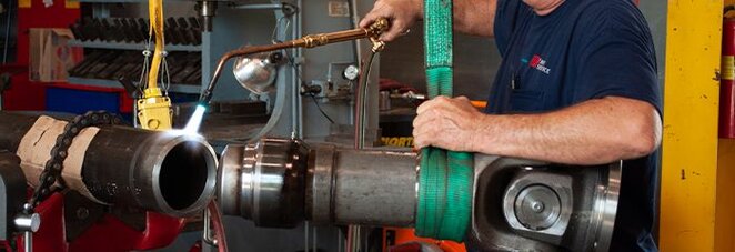 A Motion service technician uses a specialized tool as he repairs an industrial drive shaft.