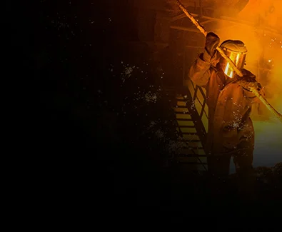 A hot, smokey forge processes iron and steel, sparks flying into the air.