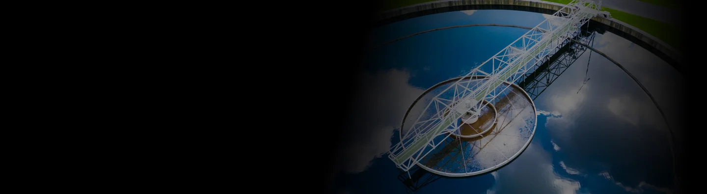 The sky can be seen reflecting off the surface of a water treatment tank.