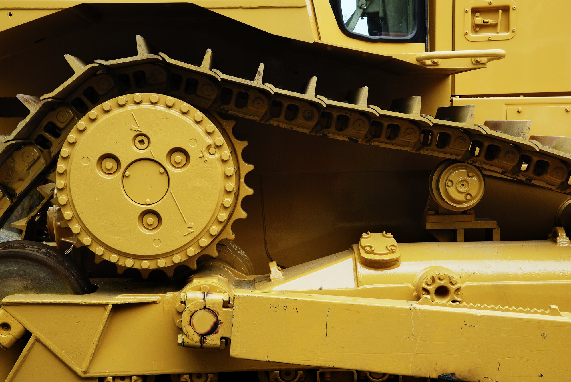 The inside of a large machine, featuring a gear and a belt.