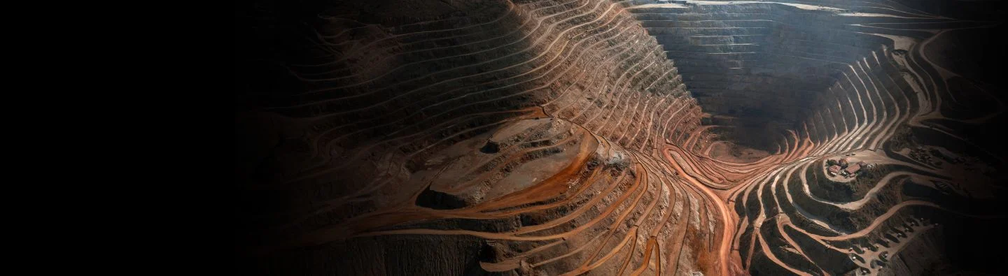 Conveyor belt transferring materials in a brightly lit mineshaft.