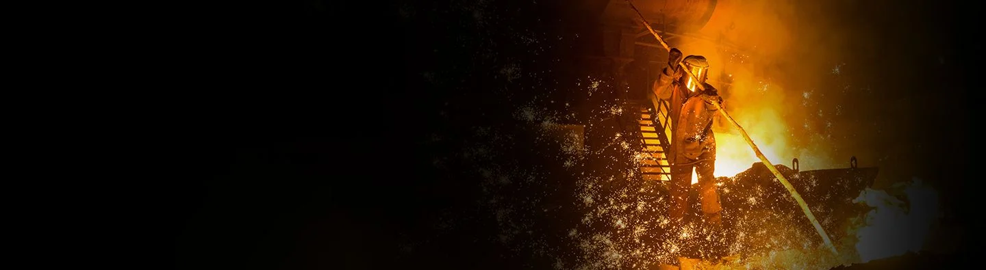 A hot, smokey forge processes iron and steel, sparks flying into the air.