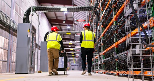 Two experienced service technicians inspect a data center.