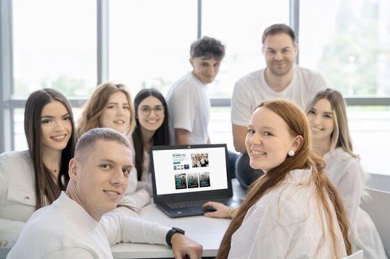 Team Bild Standort SELLWERK Nürnberg sitzen am Tisch mit einem Laptop