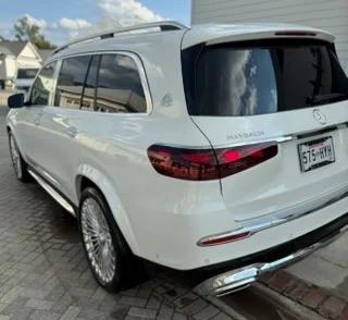 White luxury vehicle parked in professional driveway setting after detailing