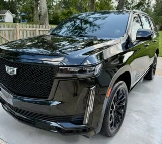 Black Cadillac Escalade SUV with dramatic lighting and premium finish