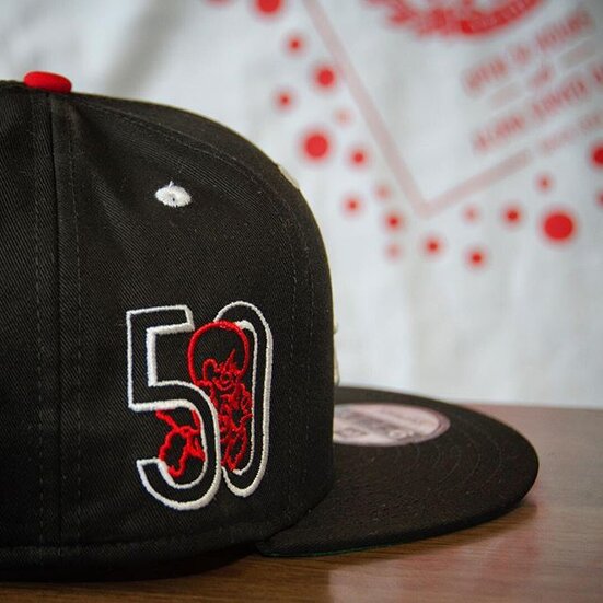 A black FITTED HAWAI‘I cap with a red Zippy’s 50 logo