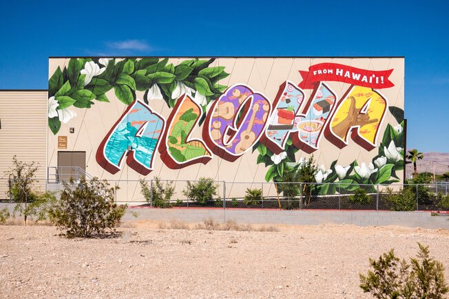 A painted ALOHA mural reading From Hawai‘i on a Zippy’s wall